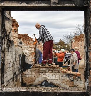Voluntários trabalhando nos escombros de um povoado perto de Chernigov, na Ucrânia (Foto Ansa)