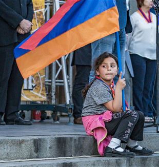 Uma menina com a bandeira armênia durante uma manifestação em Yerevan, na Armênia, para apoiar o enclave em Nagorno-Karabakh (Foto: Ansa-Zumapress)
