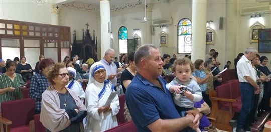 Cristãos em oração na igreja da Sagrada Família de Gaza, durante o conflito
